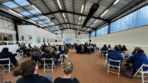 Attendees of the HETI forum in large room.