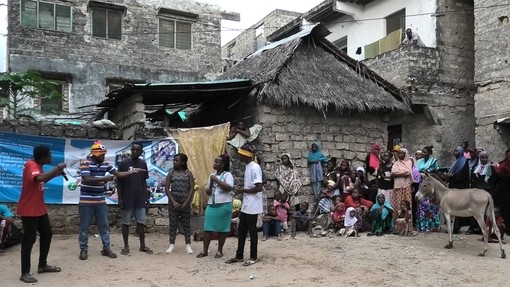 A group of six residents in Lamu performing forum theatre to a crowd of people