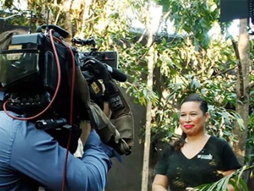 A behind the scenes view of a cameraman filming a women