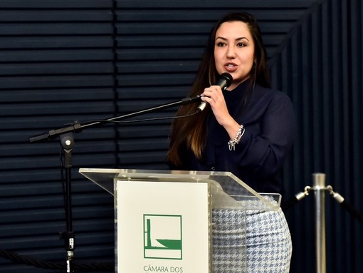 A women stood behind a podium speaking into a microphone